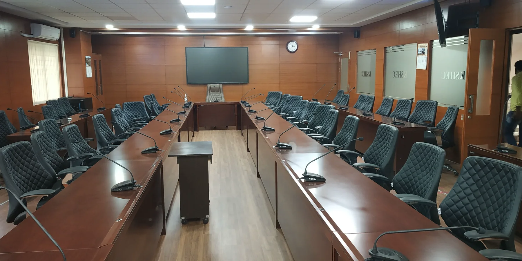 Completed video conferencing boardroom with display and delegate microphones